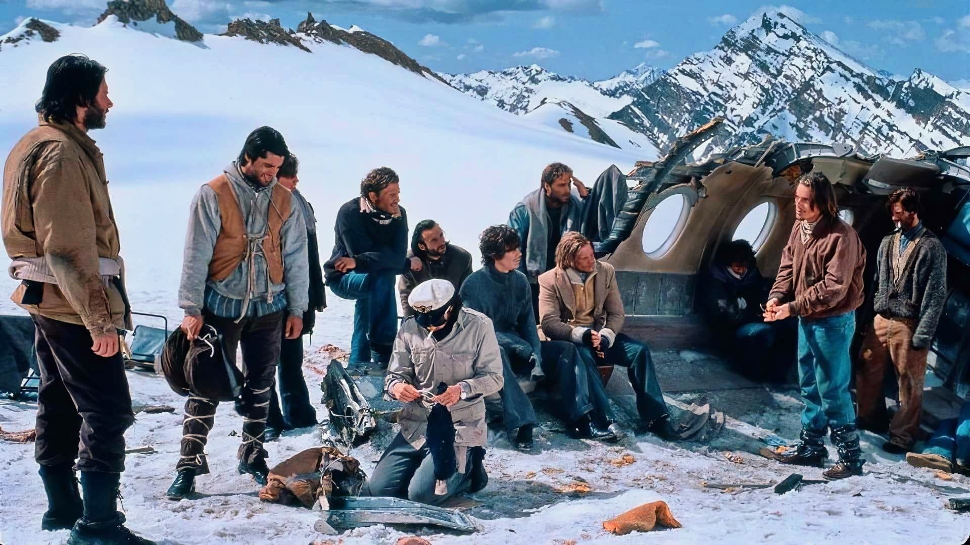 The numerous members of Alive's cast huddle together atop a snowy mountain range.