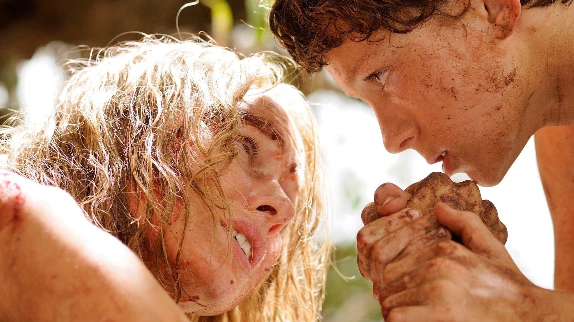 The Impossible's Tom Holland and Naomi Watts hold hands, both covered in grime.