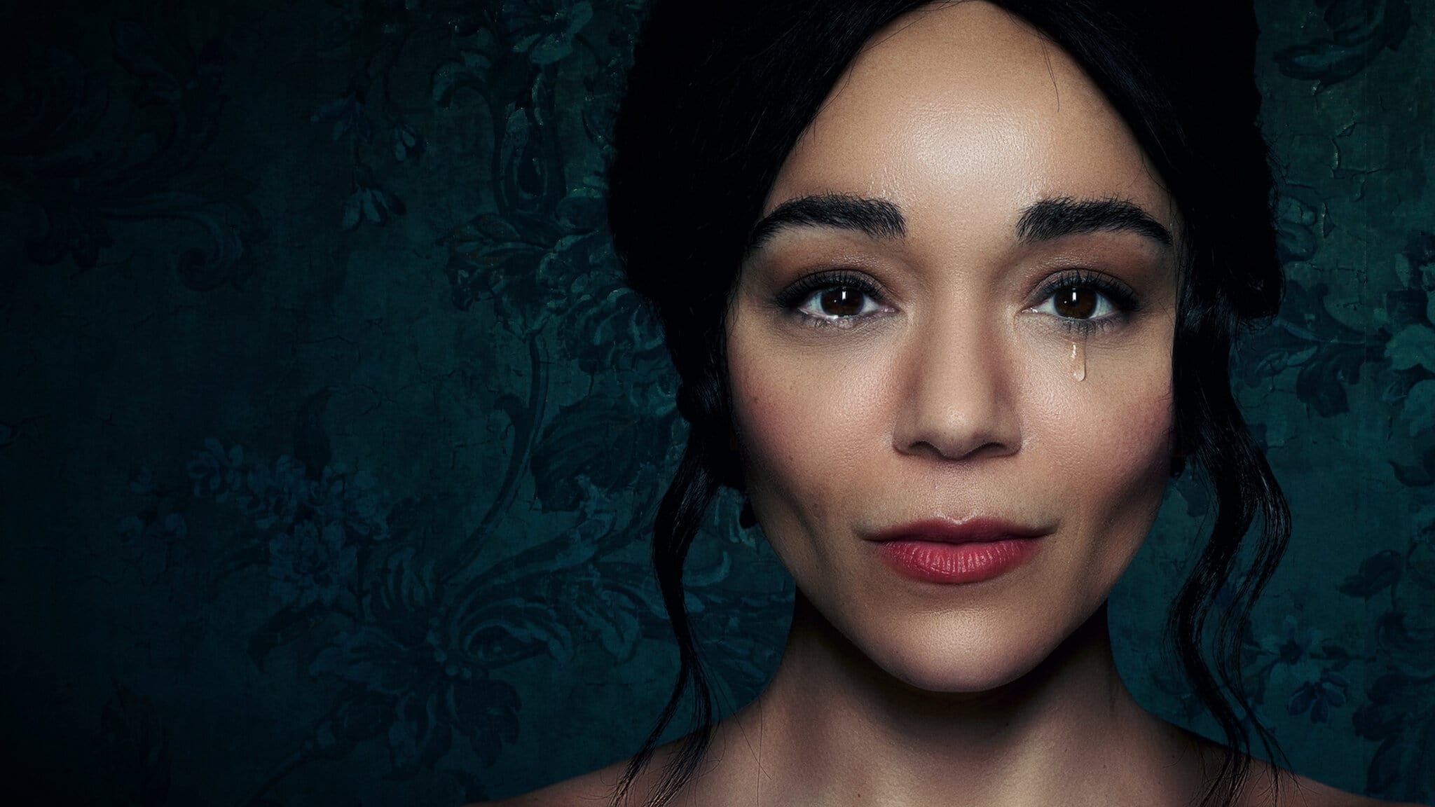 The Strays' star Ashley Madekwe sheds a tear againsr a sage background in this promotional image.