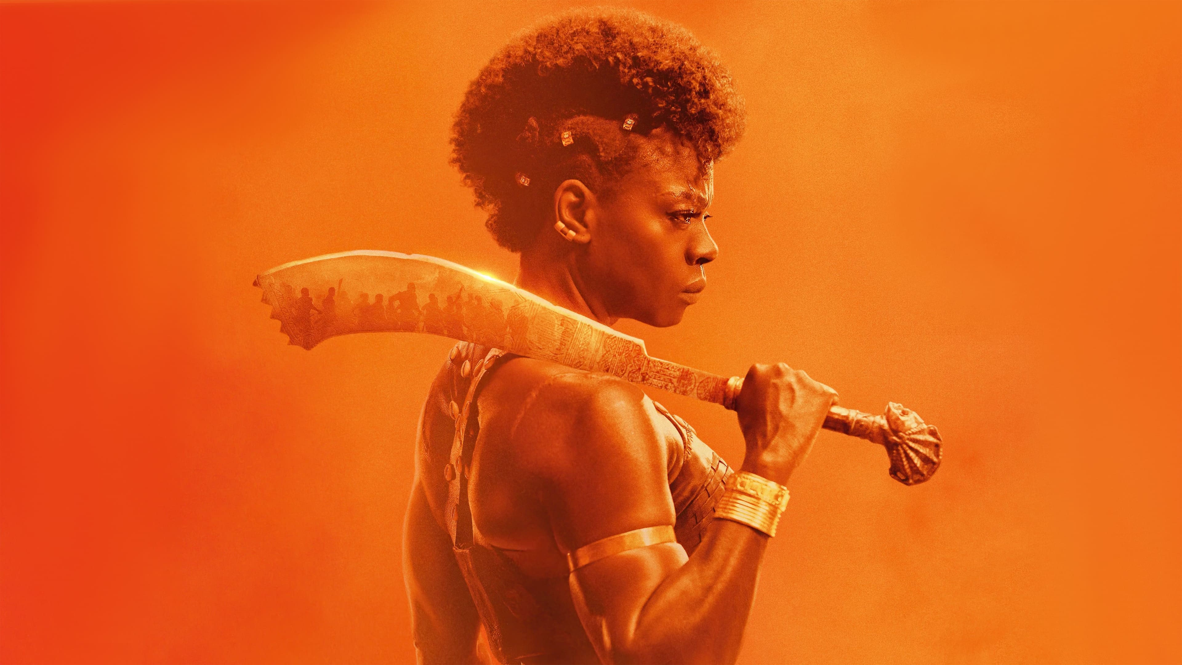 A promotional image for The Woman King shows the titular character against an orange background.